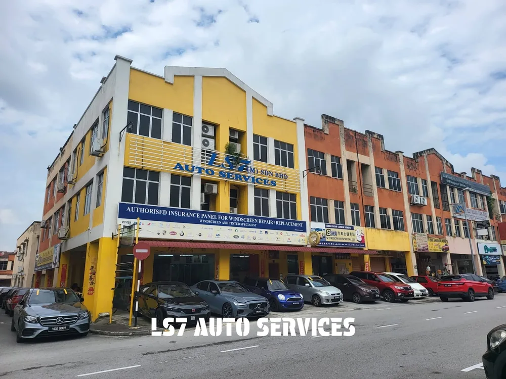 Wide view of LS7’s yellow workshop building and vehicles outside its service bays